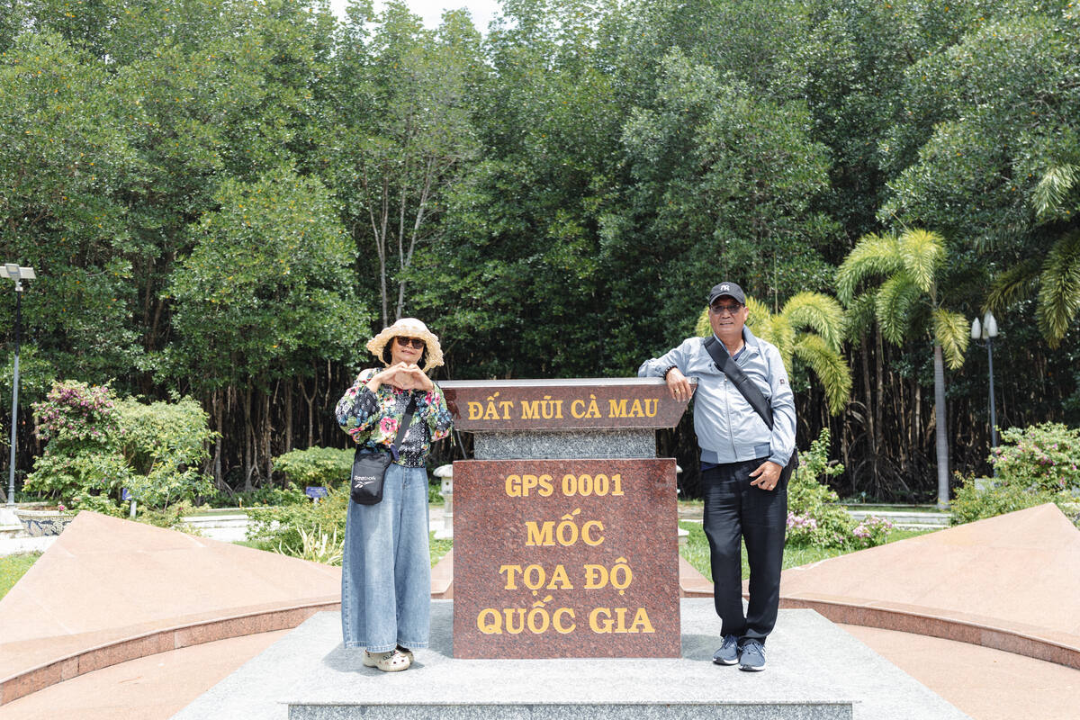 Đôi vợ chồng chụp ảnh tại mốc tọa độ GPS 0001 Đất Mũi