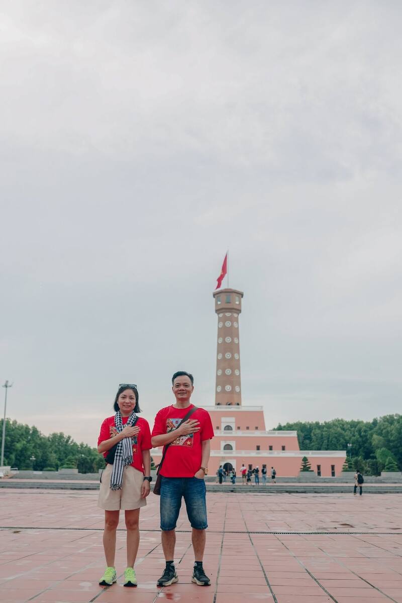 Cặp đôi đặt tay lên ngực trước cột cờ Hà Nội Đất Mũi