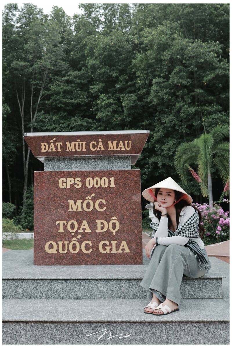 Du khách thảnh thơi ngồi bên mốc tọa độ quốc gia GPS 0001.
