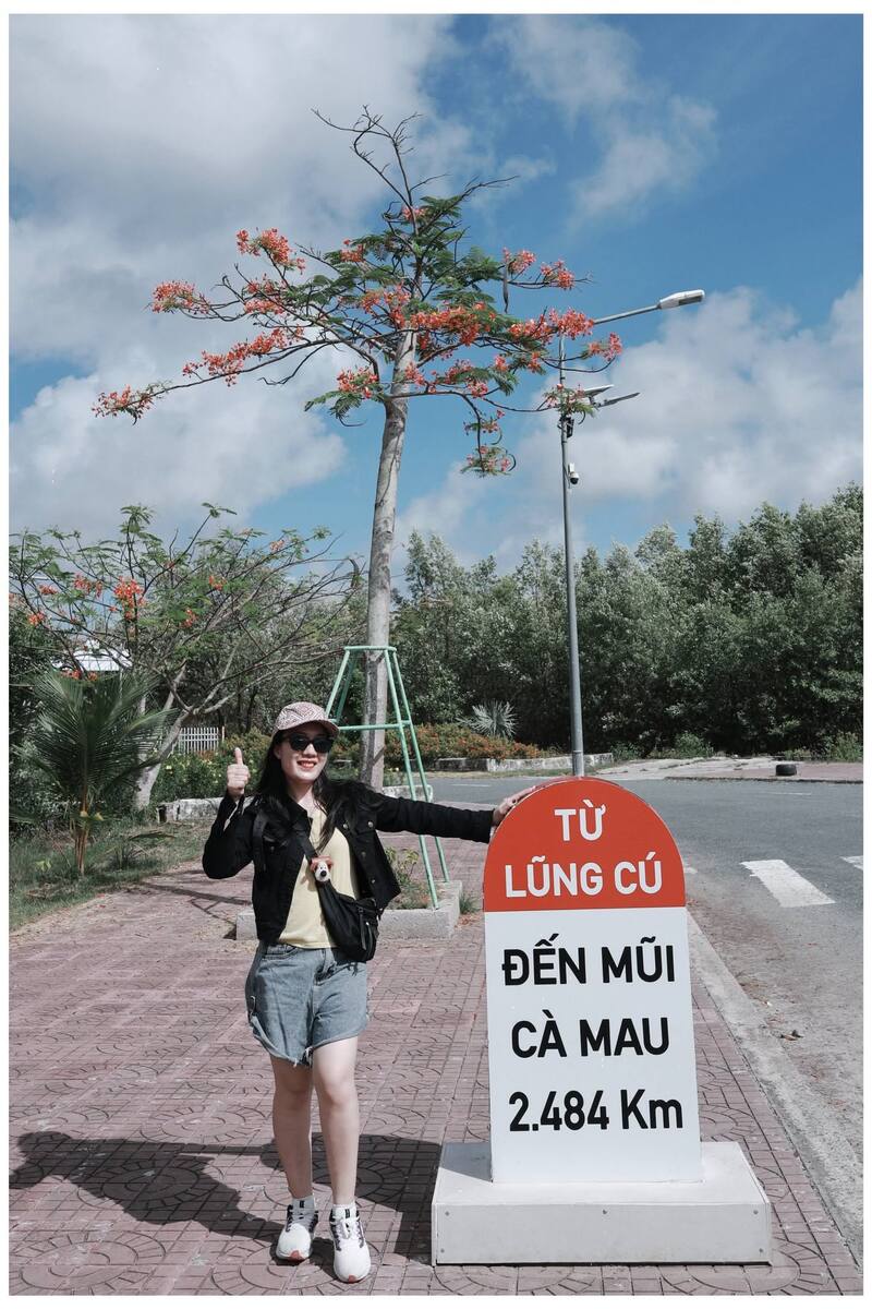Nữ du khách check-in bên cột mốc Lũng Cú - Mũi Cà Mau